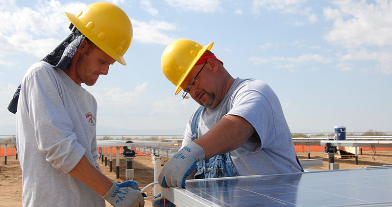 Zukunftsfähige Jobs trotz Trump: Zwei Arbeiter in den USA montieren ein Solarmodul.